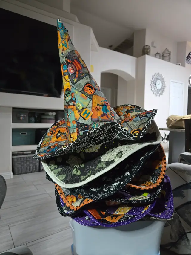 What are y'all working on today? Here's what I'm working on! About a year ago, it was decided that we would have a Halloween get-together with some good friends. And for that, I decided it would be a good idea to make everyone a witch's hat! And here we are, less than a week away, and I'm still sewing! 😂 The crowns and brims are finally pinned together (hence the picture!). Just two more sewing steps and they'll be done! I even bought chiffon chair sashes to make hatbands and bows! With the price of ribbon these days, this was a much more affordable way to get those big, dramatic bows I envisioned. We'll see how that goes! Pattern: Spellbound Quilted Witch Hat by Melissa Mortenson of Polka Dot Chair, a paid pattern available on Etsy. #halloween #witcheshat #quilting #quiltersoftiktok #quiltingismytherapy 